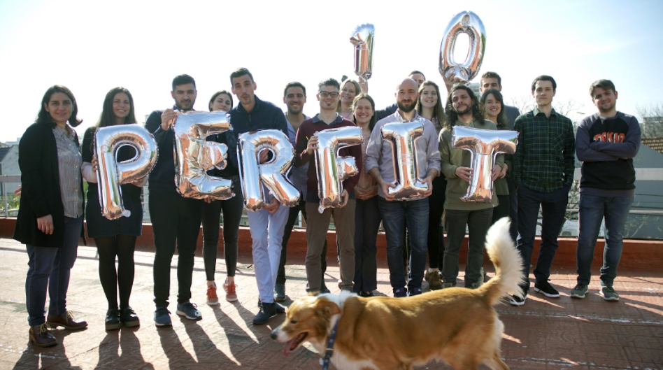empleados y fundadores sosteniendo el logo de Perfit con globos