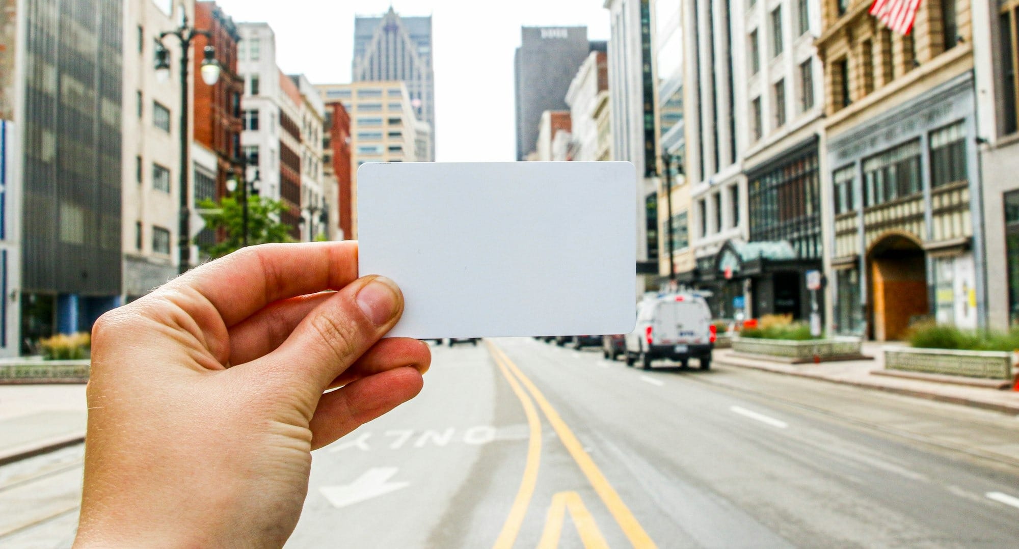 a person holding a business card in the middle of a street